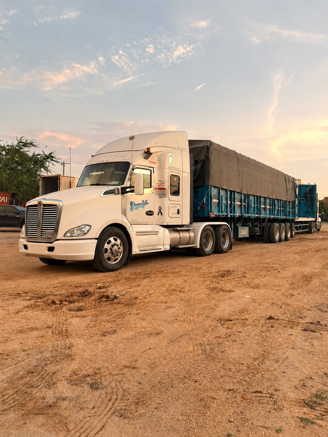 Tractocamión de TRANSEVAN con jaula cubierta por lona al atardecer